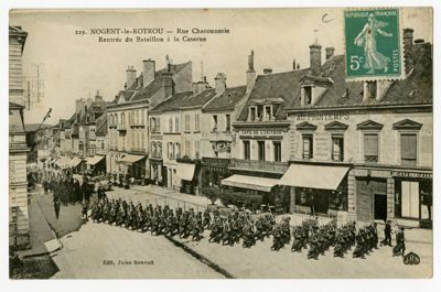Carte postale représentant la rentrée du bataillon à la caserne, Nogent-le-Rotrou, rue Charonnerie. Collection du Château Saint-Jean de Nogent-le-Rotrou.